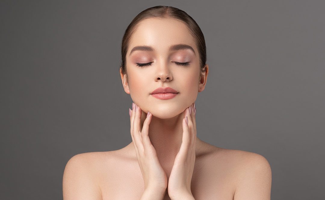 Woman touching clear skin after acne facials.