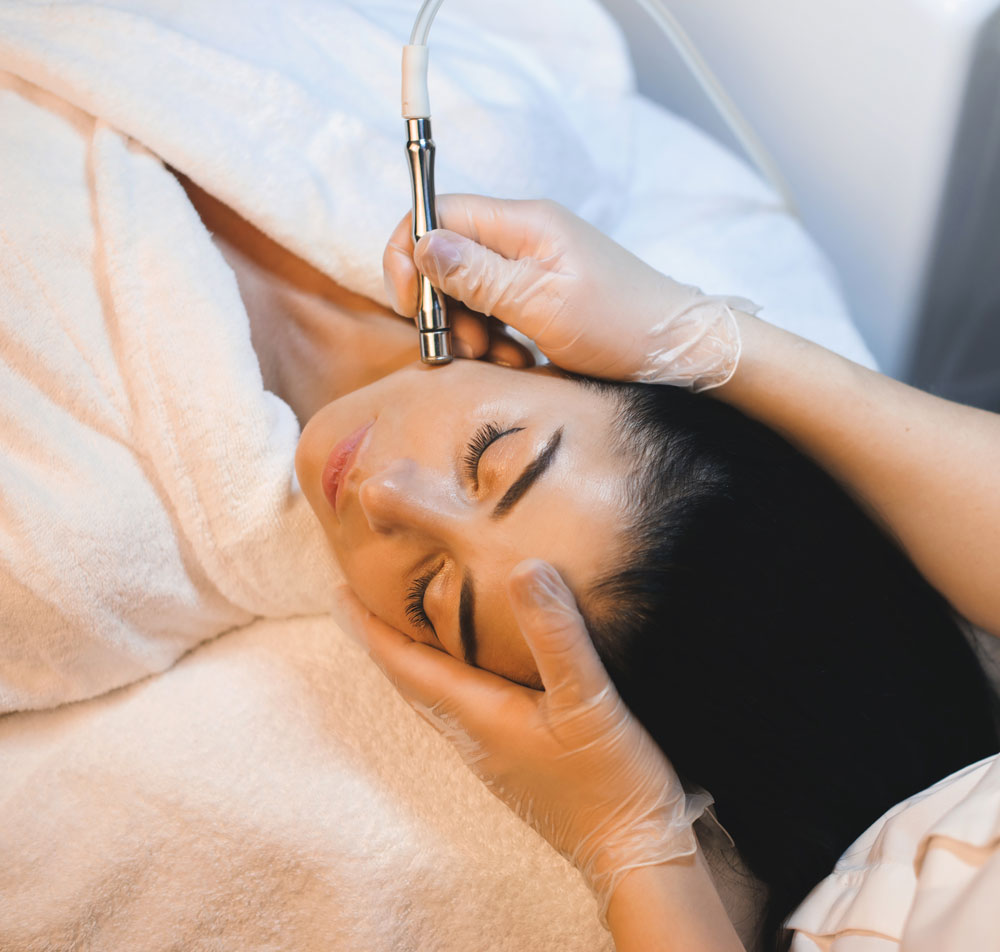 Woman receiving professional treatment for uneven skin tone and dullness.