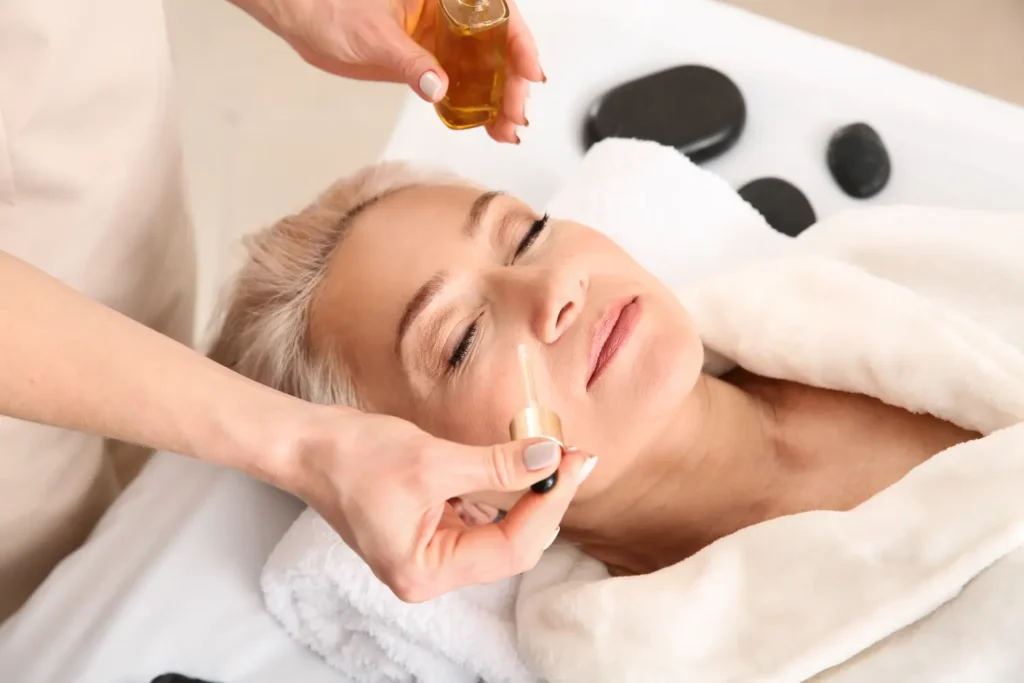 Esthetician applying serum to woman's face during spa treatment