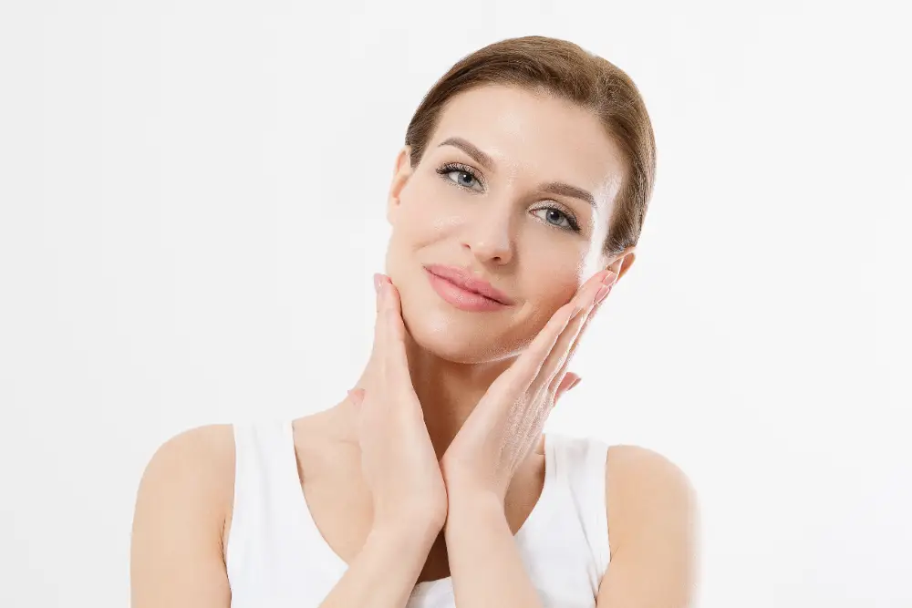 Woman touching her face with glowing, smooth skin after a facial treatment.