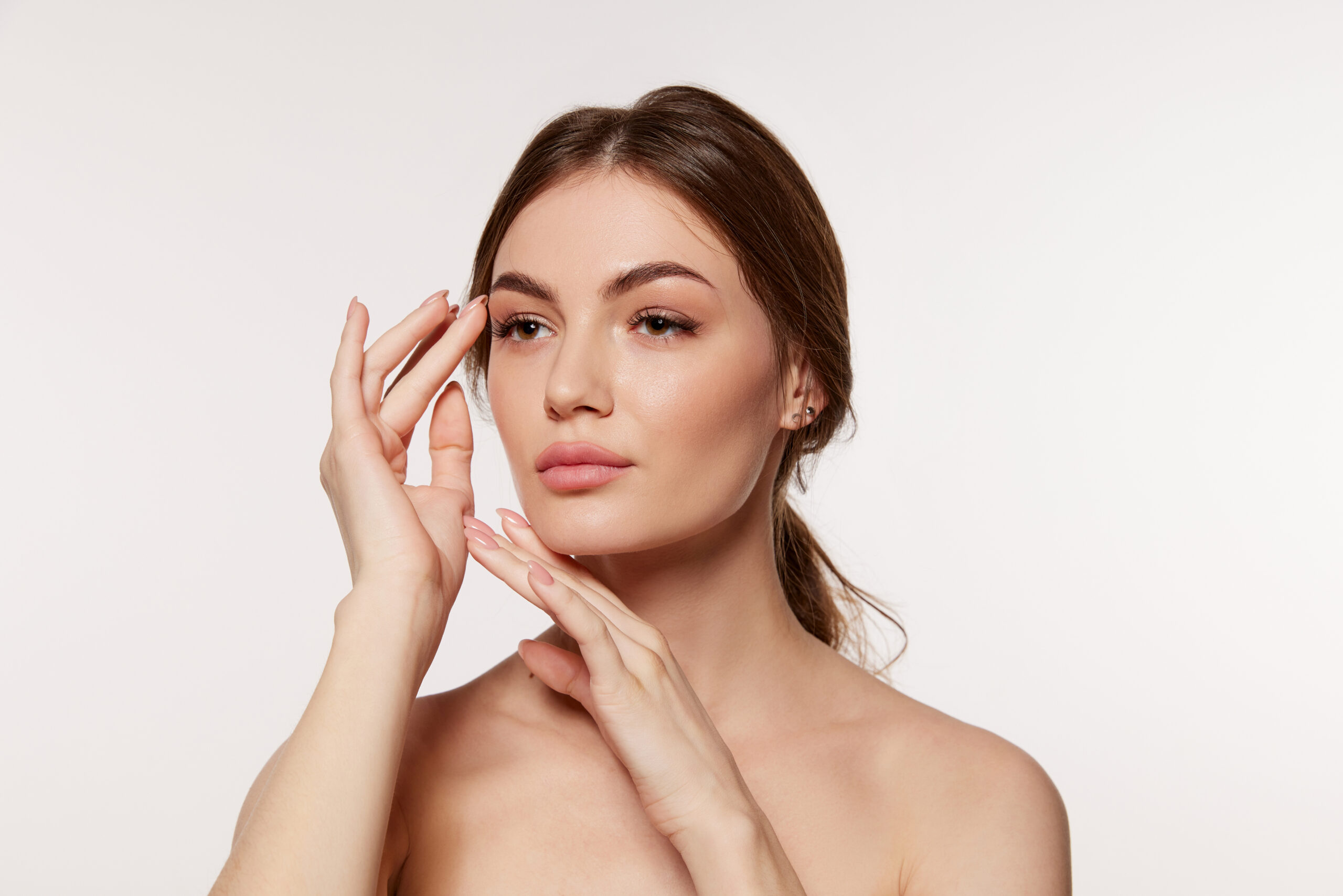 Woman with smooth glowing skin touching her face